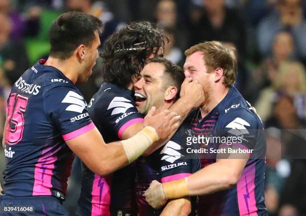 Cameron Smith of the Storm is congratulated by his teammates after scoring a try during the round 25 NRL match between the Melbourne Storm and the...
