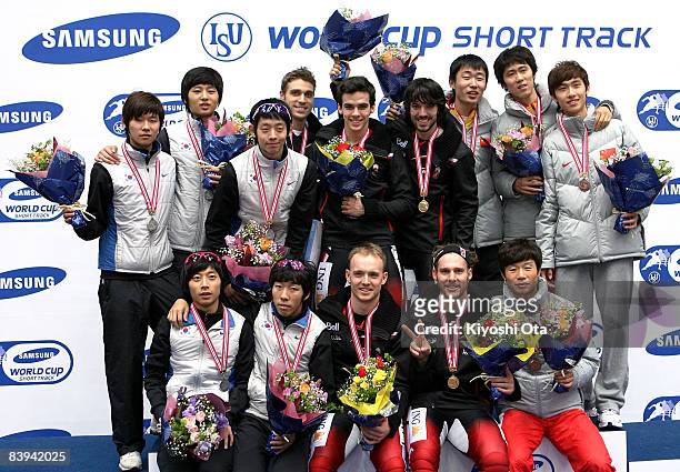 Members of the Canadian, South Korean and Chinese teams pose for photographers on the podium at the award ceremony after the Men's 5000m Relay final...