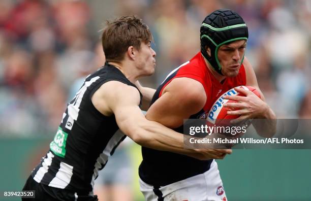 Angus Brayshaw of the Demons is tackled by Josh Thomas of the Magpies during the 2017 AFL round 23 match between the Collingwood Magpies and the...