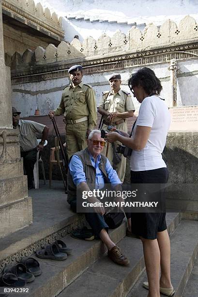 Italian tourists prepare to leave as Indian Police officers stand guard at the Shahi Jama Masjid Mosque in Ahmedabad on 7 December 2008. . India's...