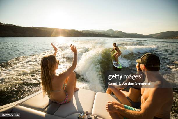 a group of freinds enjoying a day at the lake - wakeboarden stock-fotos und bilder