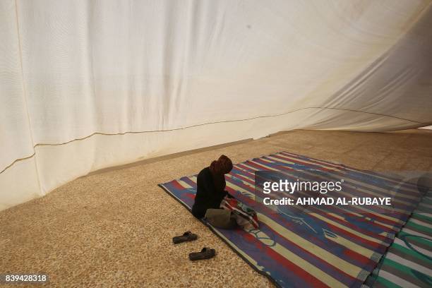 Displaced Iraqi woman, who fled the fight between Iraqi forces and the Islamic State group in Tal Afar, sits inside a tent at the Badush camp, 150...