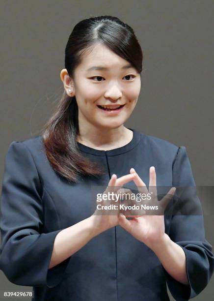 Princess Mako, the eldest granddaughter of Emperor Akihito and Empress Michiko, signs an address during a high school sign language contest in Tokyo...