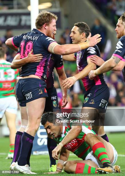 Tim Glasby of the Storm celebrates with Billy Slater and his teammates after scoring a try during the round 25 NRL match between the Melbourne Storm...