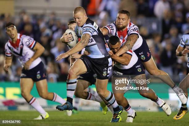 Luke Lewis of the Sharks is tackled from behind by Jared Waerea-Hargreaves of the Roosters during the round 25 NRL match between the Cronulla Sharks...