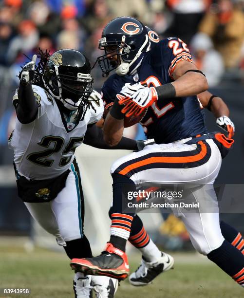 Matt Forte of the Chicago Bears runs with the ball as Reggie Nelson of the Jacksonville Jaguars closes in on December 7, 2008 at Soldier Field in...