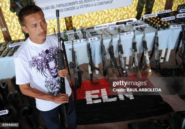 Member of the National Liberation Army holds his AK-47 before surrendering it to the Colombian Army on December 7 in Quibdo, department of Choco,...