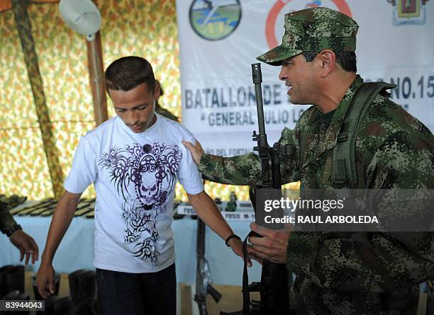 Member of the National Liberation Army surrenders his AK-47 to the Colombian Army on December 7 in Quibdo, department of Choco, Colombia. According...