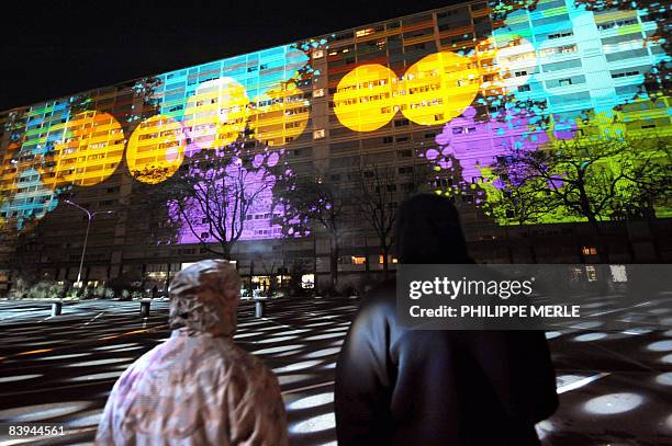 Inhabitants look at a performance on a social housing building which will be demolished in one year at La Duchere district in Lyon, central eastern...