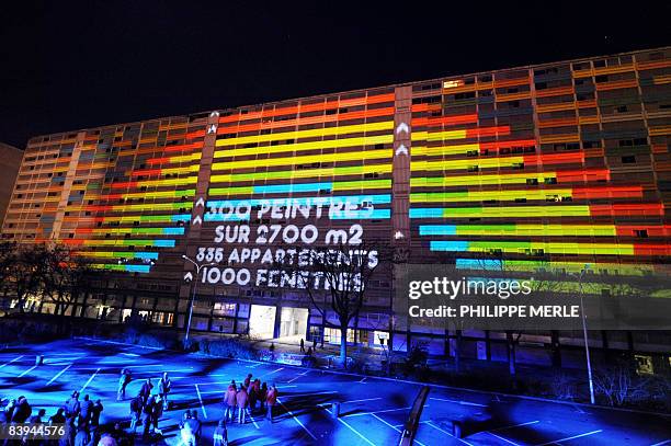 Inhabitants look at a performance on a social housing building which will be demolished in one year at La Duchere district in Lyon, central eastern...