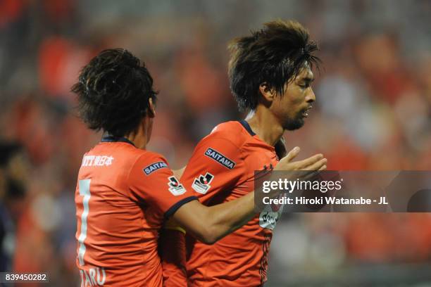 Kosuke Kikuchi of Omiya Ardija celebrates scoring his side's first goal with his team mate Ataru Esaka during the J.League J1 match between Omiya...