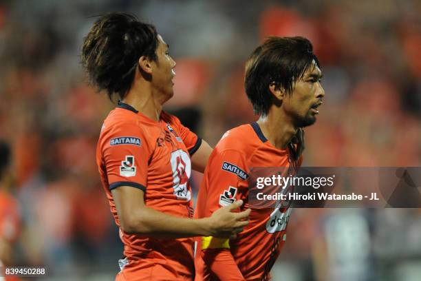 Kosuke Kikuchi of Omiya Ardija celebrates scoring his side's first goal with his team mate Ataru Esaka during the J.League J1 match between Omiya...