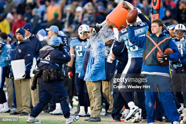 Head Coach Jeff Fisher of the Tennessee Titans has water dumped on him to celebrate winning the AFC South during a game against the Cleveland Browns...