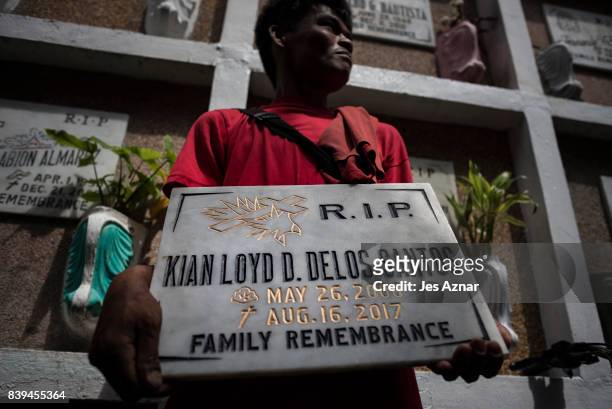 The tombstone of Kian Delos Santos is being carried by a supporter on August 26, 2017 in Caloocan city, Philippines. More than a thousand Filipinos...
