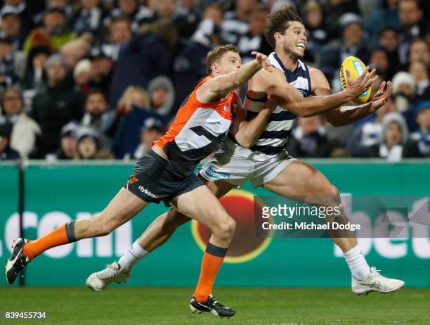 Tom Hawkins of the Cats marks the ball against Heath Shaw of the Giants during the round 23 AFL match between the Geelong Cats and the Greater...