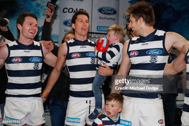 Andrew Mackie of the Cats celebrates with Patrick Dangerfield and Tom Lonergan as his child cries during the round 23 AFL match between the Geelong...