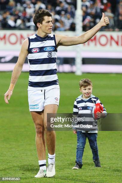 Andrew Mackie of the Cats waves to fans after their win with his kids during the round 23 AFL match between the Geelong Cats and the Greater Western...