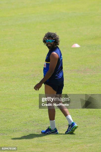 Sri Lankan cricketer Lasith Malinga looks on as his team mates play football during a practice session ahead of the 3rd ODI cricket match against...