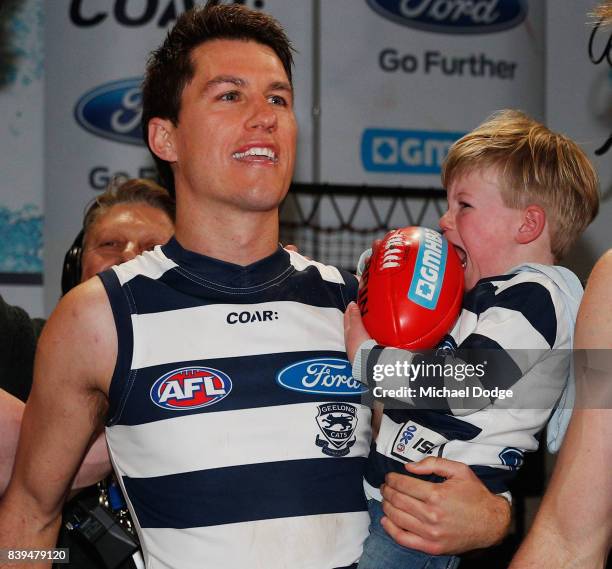 Andrew Mackie of the Cats celebrates the song as his child cries during the round 23 AFL match between the Geelong Cats and the Greater Western...