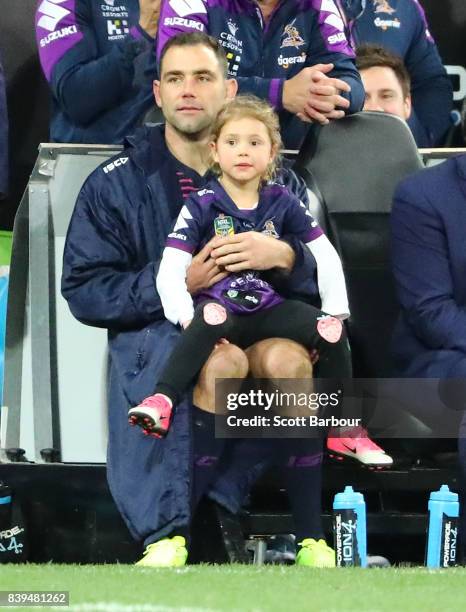 Cameron Smith of the Storm sits on the bench with his daughter during the round 25 NRL match between the Melbourne Storm and the South Sydney...