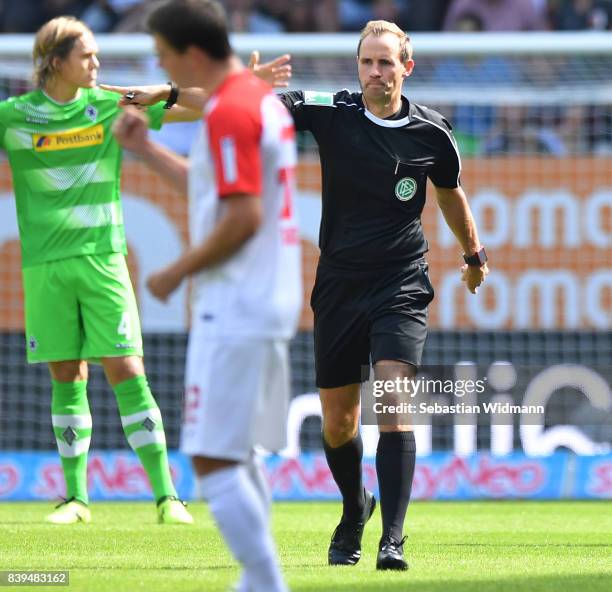 Referee Sascha Stegemann proves the first goal after he checked with the video referee, during the Bundesliga match between FC Augsburg and Borussia...