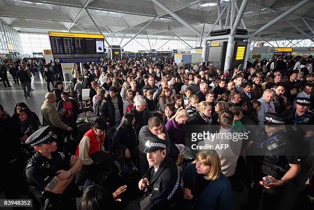 Passengers wait for flight information in Stansted's main terminal after protesters caused major delays by occupying a secure area near the runway on...