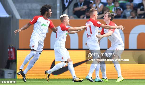Alfreo Finnbogason of Augsburg celebrates with Michael Gregoritsch of Augsburg after he scored to make it 1:0 with Philipp Max of Augsburg during the...