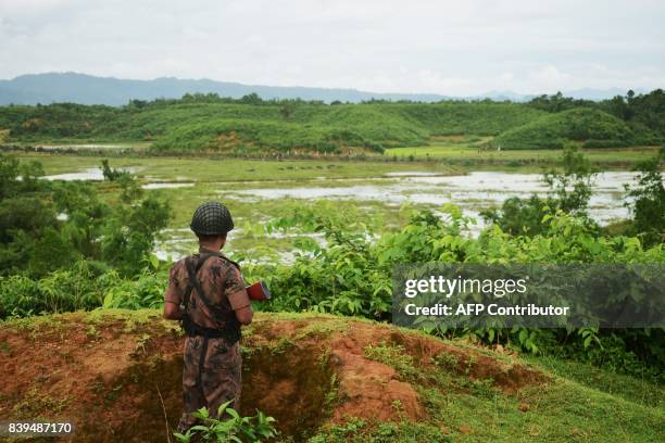 Border Guard Bangladesh personnel stands alert in a bunker as Rohingya people escape fresh gunfire at the Bangladesh-Myanmar frontier near Rakhine on...