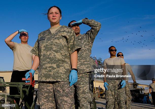 Military hospital staff wait by the helipad for a helicopter to arrive with two trauma patients at the combat support hospital on the U.S military...