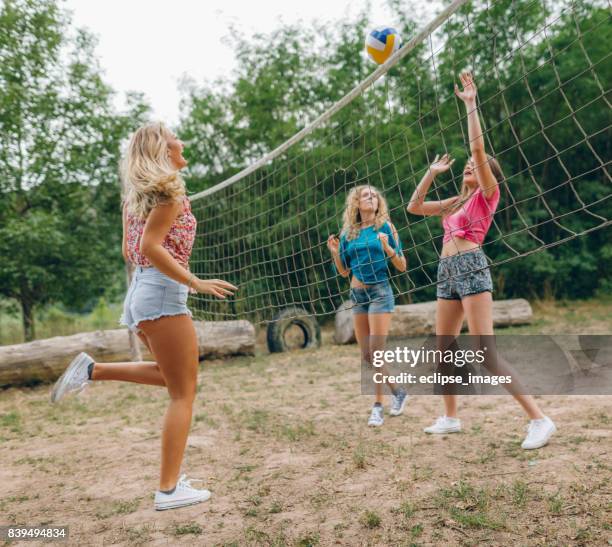 friends playing volleyball at public park - candid volleyball stock pictures, royalty-free photos & images