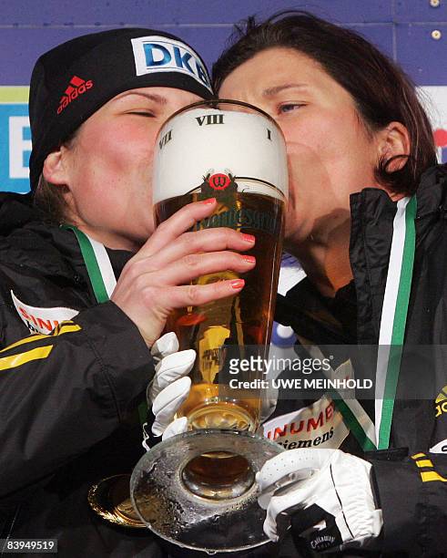 Germany's Sandra Kiriasis and Berit Wiacker celebrate with a beer winning the two-woman sled event at the Bobsleigh World Cup in the eastern German...
