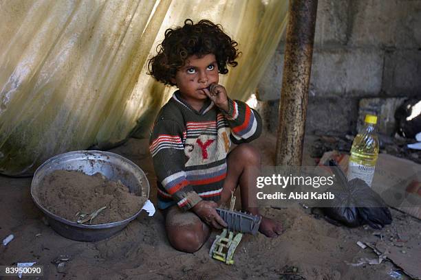 Young Palestinian Bedouin girl plays with broken toys on the dirt floor of her family's shanty home in a marginal community on on November 3, 2008 in...