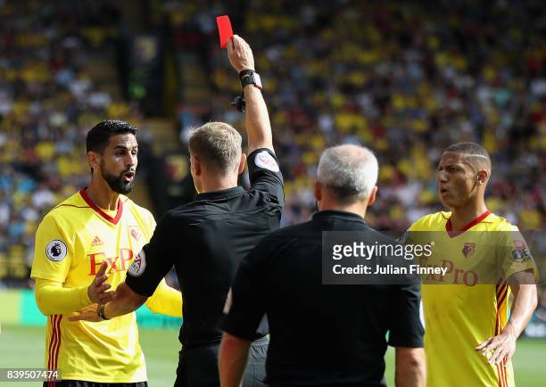 Referee Graham Scott shows a red card to Miguel Britos of Watford during the Premier League match between Watford and Brighton and Hove Albion at...