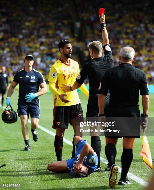 Referee Graham Scott shows a red card to Miguel Britos of Watford during the Premier League match between Watford and Brighton and Hove Albion at...