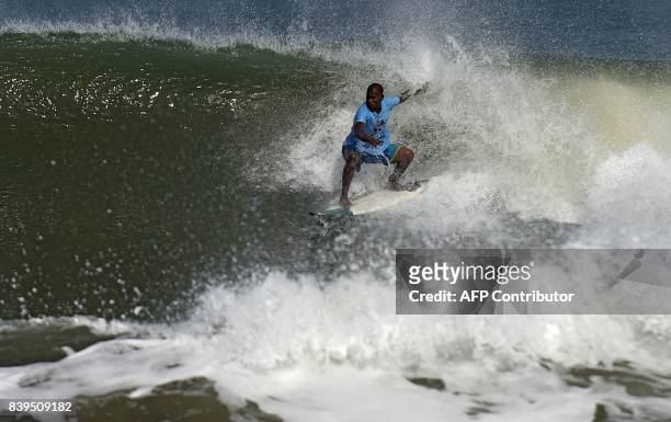 Indian man surfs during the annual Covelong Point Classic Surf festival at Kovalam on the outskirts of Chennai on August 26, 2017. / AFP PHOTO / ARUN...