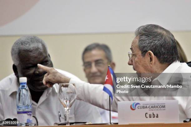 President Raul Castro of Cuba points as he talks to Vice-President Esteban Lazo prior to the opening session of the third CARICOM summit, a trade...
