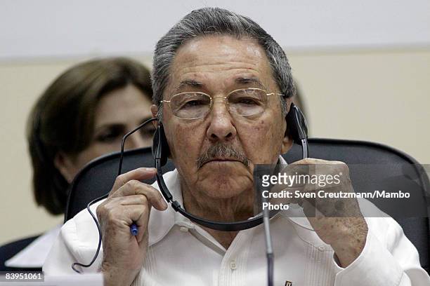 President Raul Castro of Cuba adjusts his headphones during the opening session of the third CARICOM summit, a trade organization of 14 Caribbean...