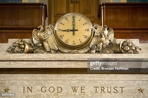 Clock and the motto "In God We Trust" over the Speaker's rostrum in the U.S. House of Representatives chamber are seen December 8, 2008 in...