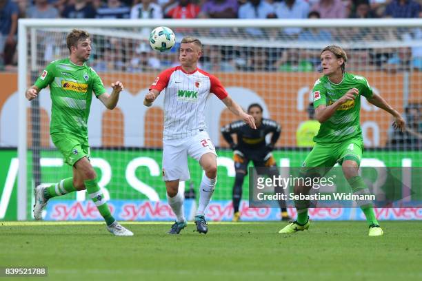 Christoph Kramer of Moenchengladbach , Alfreo Finnbogason of Augsburg and Jannik Vestergaard of Moenchengladbach during the Bundesliga match between...