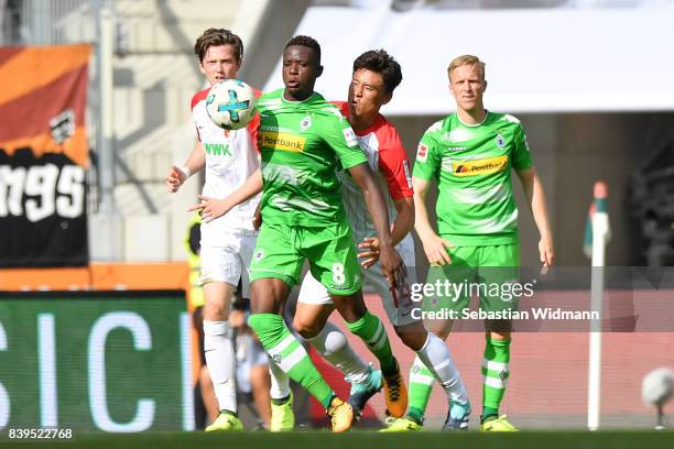 Michael Gregoritsch of Augsburg , Denis Zakaria of Moenchengladbach, Ja-Cheol Koo of Augsburg and Oscar Wendt of Moenchengladbach during the...