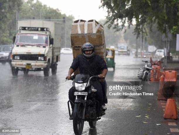 Commuters caught during heavy rain, on August 26, 2017 in New Delhi, India. The rains brought much respite to the residents from the prevailing warm...