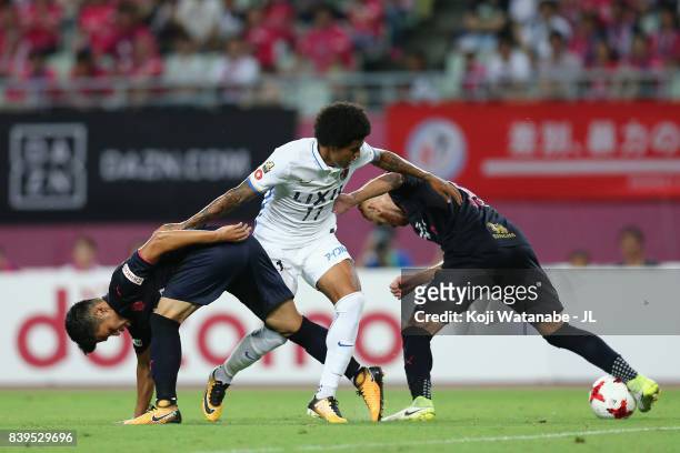 Leandro of Kashima Antlers competes for the ball against Hotaru Yamaguchi and Souza of Cerezo Osaka during the J.League J1 match between Cerezo Osaka...