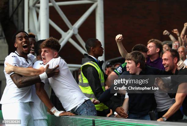 Jordan Ayew of Swansea City celebrates scoring his sides second goal with his team mates and the Swansea City fans during the Premier League match...