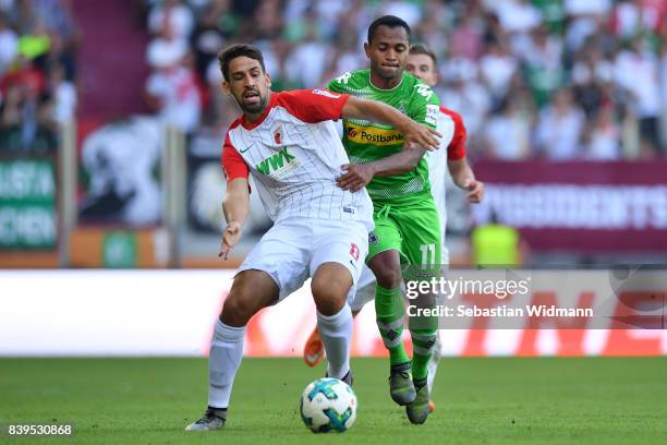 Raffael of Moenchengladbach fights for the ball with Rani Khedira of Augsburg during the Bundesliga match between FC Augsburg and Borussia...