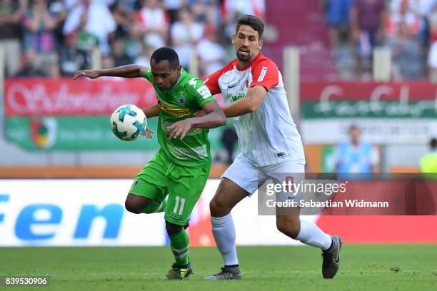 Raffael of Moenchengladbach fights for the ball with Rani Khedira of Augsburg during the Bundesliga match between FC Augsburg and Borussia...