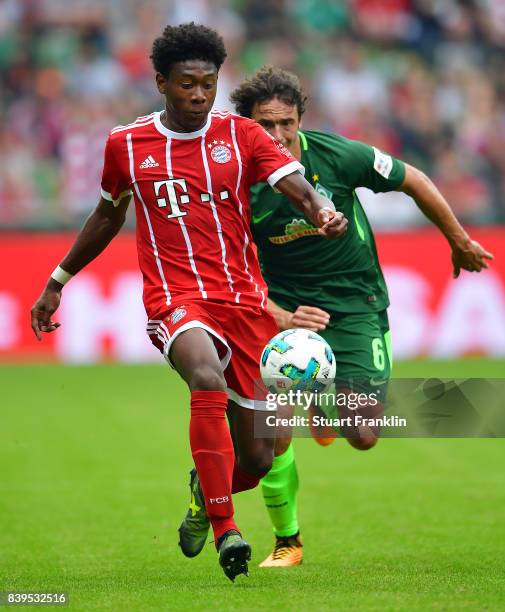 David Alaba of Bayern Muenchen is chased by Thomas Delaney of Bremen during the Bundesliga match between SV Werder Bremen and FC Bayern Muenchen at...