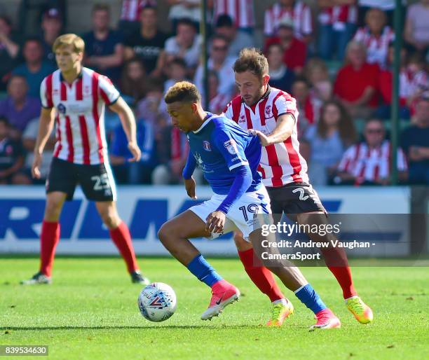 Lincoln City's Neal Eardley vies for possession with Carlisle United's Reggie Lambe during the Sky Bet League Two match between Lincoln City and...