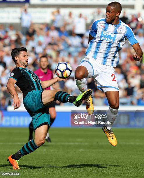 Shane Long of Southampton and Collin Quaner of Huddersfield Town battle for possession during the Premier League match between Huddersfield Town and...