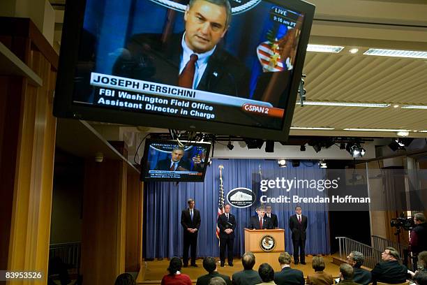 Joseph Persichini, Jr. , Assistant Director in Charge of the FBI's Washington Field Office, is seen on television monitors as he holds a news...