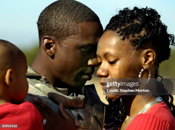 Army Sgt. Jatorrio Brooks holds his wife Stephanie Brooks and son TyReeq Brooks during a homecoming ceremony for 200 soldiers with the 4th Brigade...